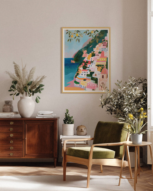 Living room with a Colorful Positano Amalfi Coast art print with lemon trees and Mediterranean sea in a pastel impressionist painting style, wooden furniture, and decorative plants.